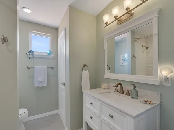 a bathroom with a granite countertop sink a mirror and shower