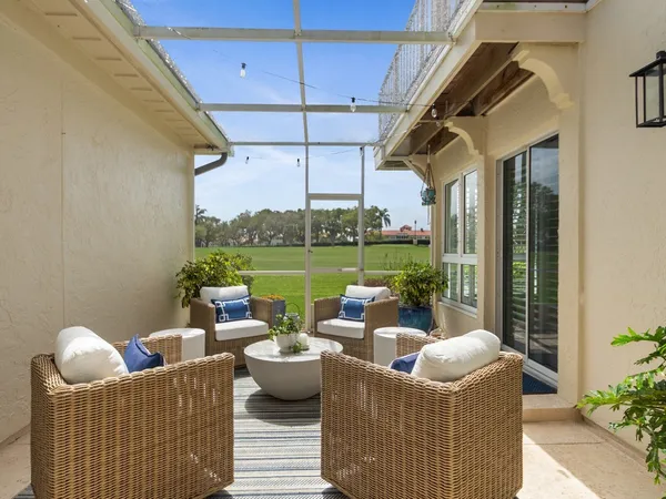a view of a patio with couches chairs potted plants and water view