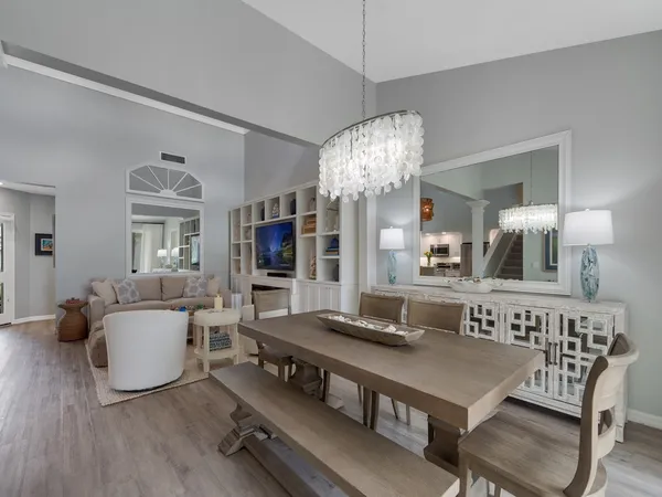 a living room with furniture a chandelier and a flat screen tv