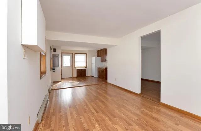 a view of a big room with wooden floor and windows