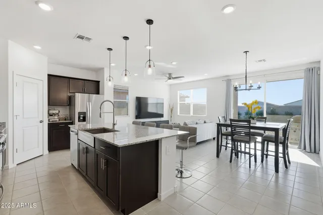 a open kitchen with stainless steel appliances granite countertop a stove and a table