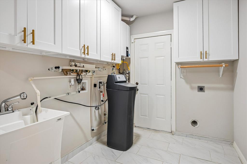 2001 Pebblebrook Trail Irving, TX 75060 - Photo 28 of 40 The laundry room has lots of storage, a sink, water softner and tankless water heater. The