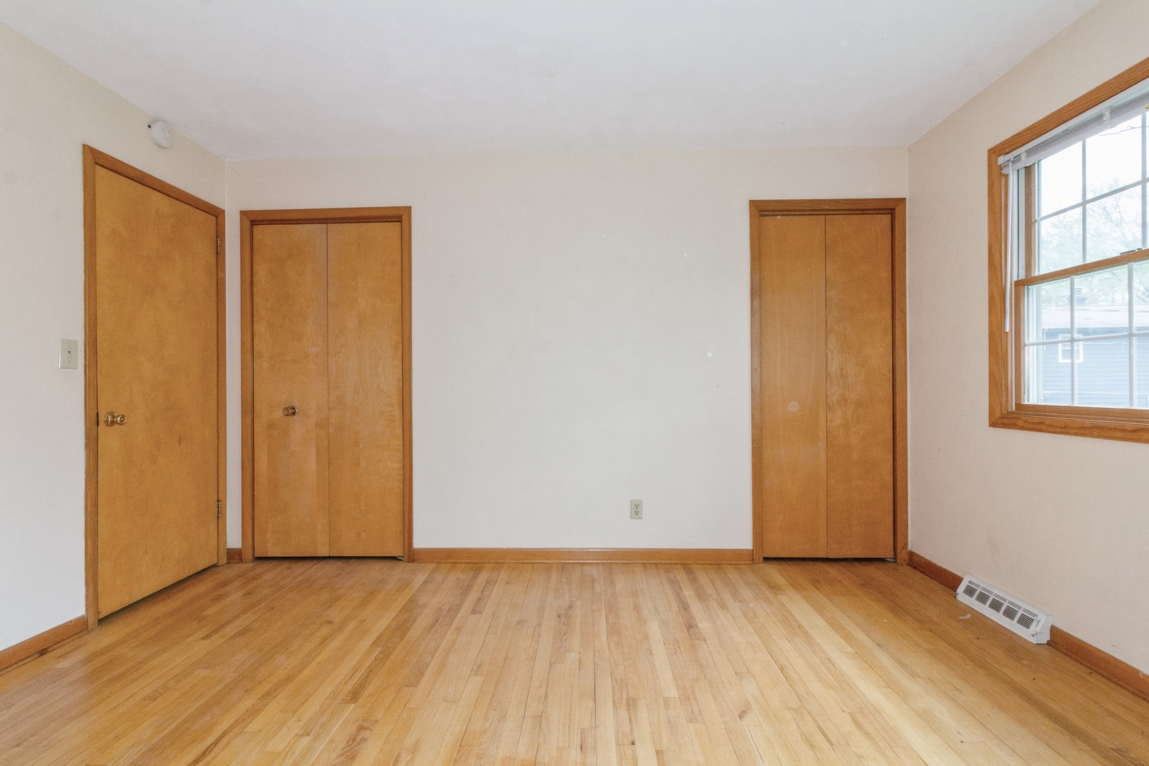 618 Russell Road DeKalb, IL 60115 - Photo 8 of 14 an empty room with wooden floor and windows
