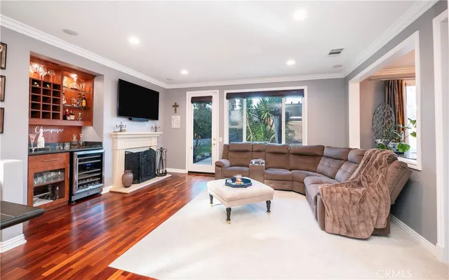 a open kitchen with stainless steel appliances granite countertop a stove top oven a refrigerator a dining table and chairs with wooden floor