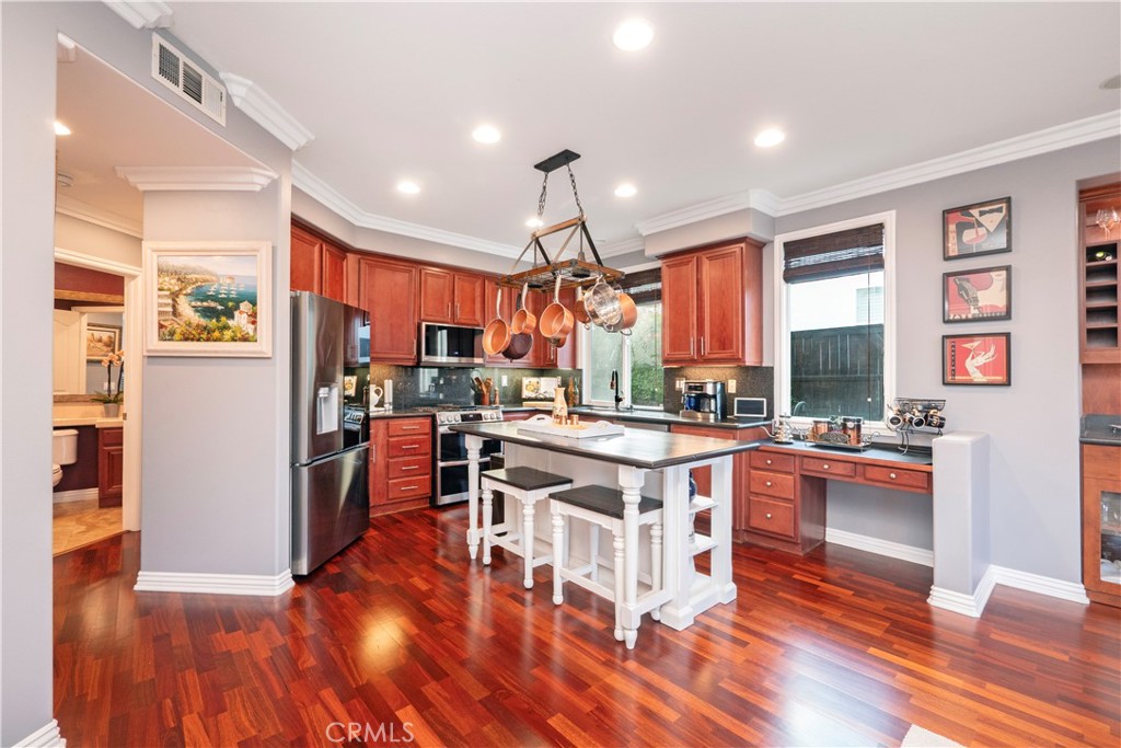 20642 Iris Canyon Road Riverside, CA 92508 - Photo 16 of 57 a open kitchen with stainless steel appliances granite countertop a stove top oven a refrigerator a dining table and chairs with wooden floor