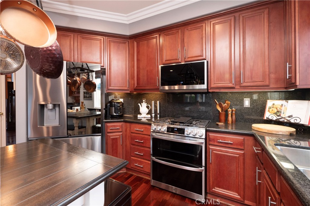 20642 Iris Canyon Road Riverside, CA 92508 - Photo 19 of 57 a kitchen with stainless steel appliances granite countertop a stove top oven a sink dishwasher and cabinets with wooden floor