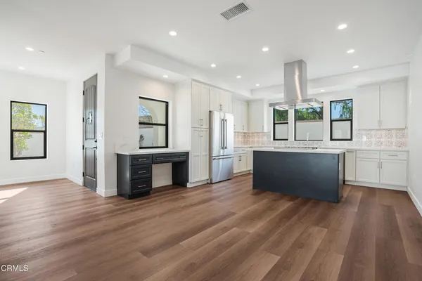 a view of kitchen with wooden floor and electronic appliances