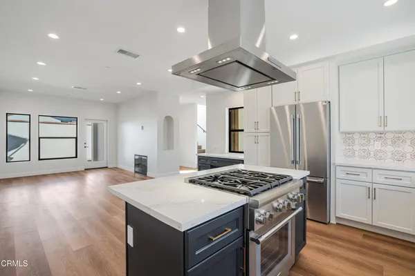a kitchen with a stove a refrigerator and cabinets