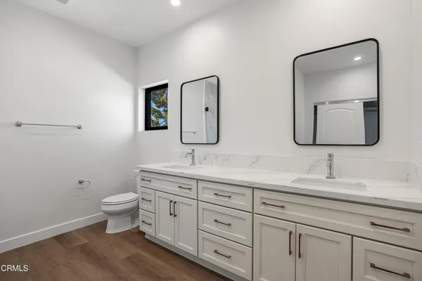 a bathroom with 2 toilet sink and a mirror