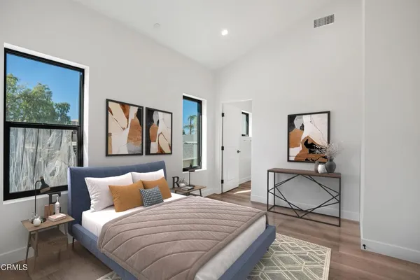 a bedroom with a bed and wooden floor