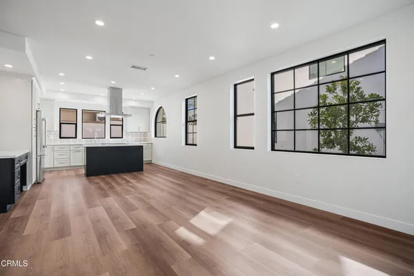 a view of kitchen with stainless steel appliances kitchen island wooden floor and window