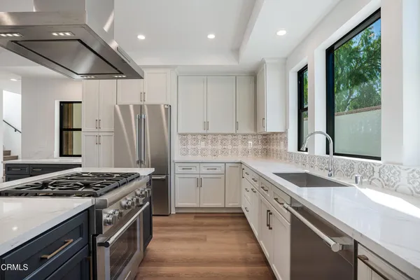 a kitchen with stainless steel appliances granite countertop a sink stove and refrigerator