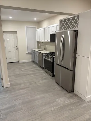 a kitchen with stainless steel appliances a refrigerator and a stove top oven