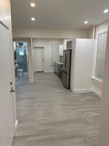 a view of a refrigerator in kitchen and an empty room