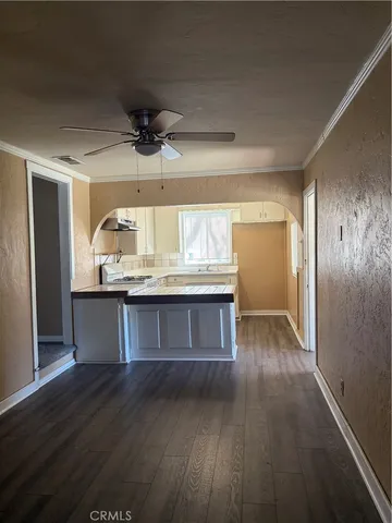 a kitchen with kitchen island granite countertop a refrigerator and wooden floor