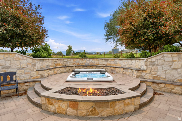 71 Farm Road Midway, UT 84049 - Photo 39 of 92 Expansive terraced patio featuring a built-in spa, a stone fire pit, and stone retaining walls