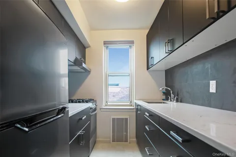 a room with a sink cabinets and a window