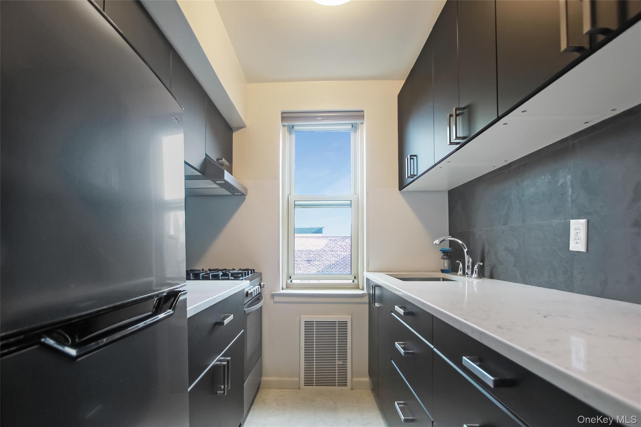 30 North Broadway, Unit 4C White Plains, NY 10601 - Photo 4 of 11 a room with a sink cabinets and a window