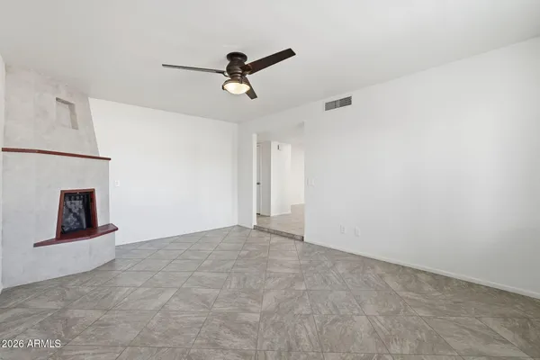 a view of an empty room with a chandelier fan