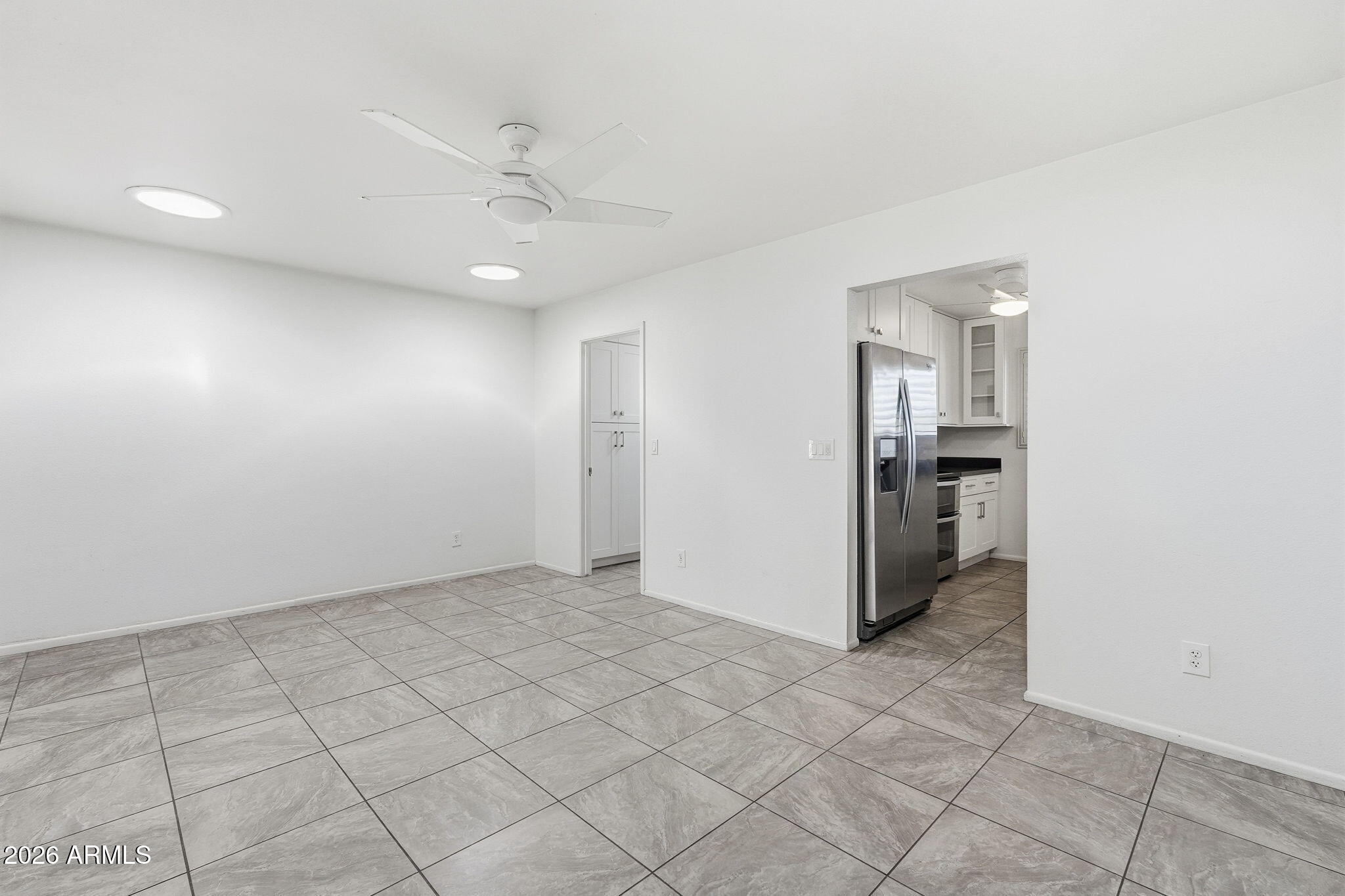 5352 South Country Club Way Tempe, AZ 85283 - Photo 4 of 42 an empty room with kitchen and chandelier fan