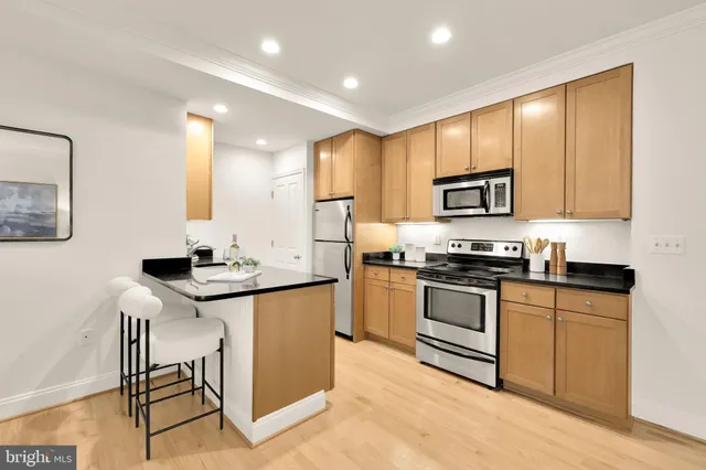 a kitchen with stainless steel appliances granite countertop a sink stove and microwave