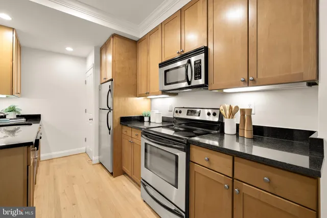 a kitchen with stainless steel appliances granite countertop a stove a sink and a refrigerator