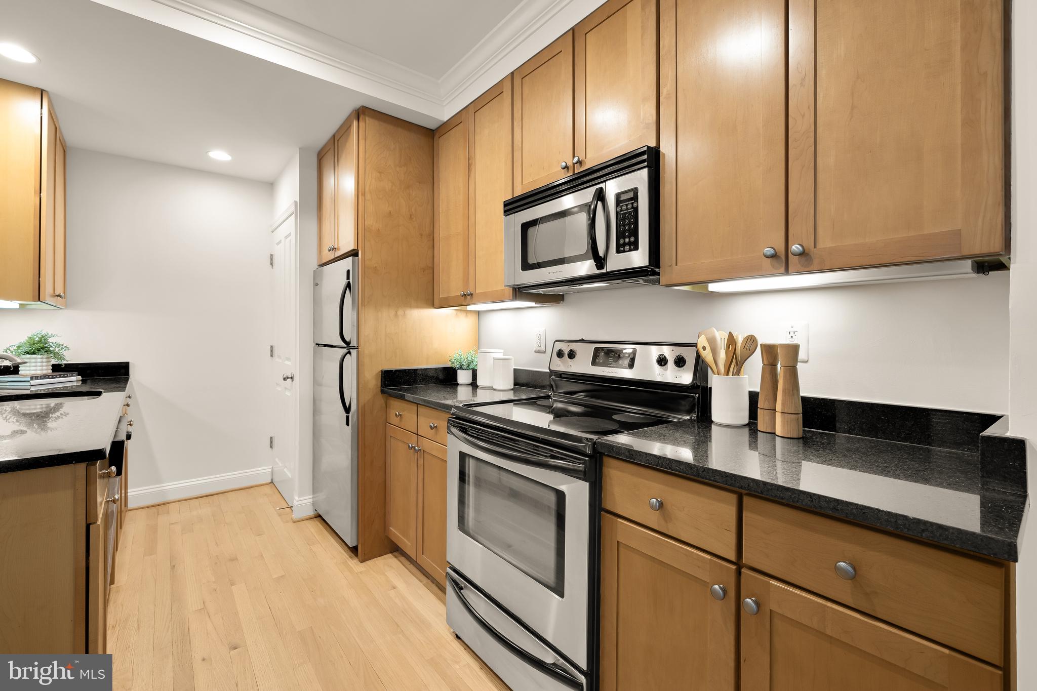 1701 16th Street Northwest, Unit 822 Washington, DC 20009 - Photo 5 of 19 a kitchen with stainless steel appliances granite countertop a stove a sink and a refrigerator