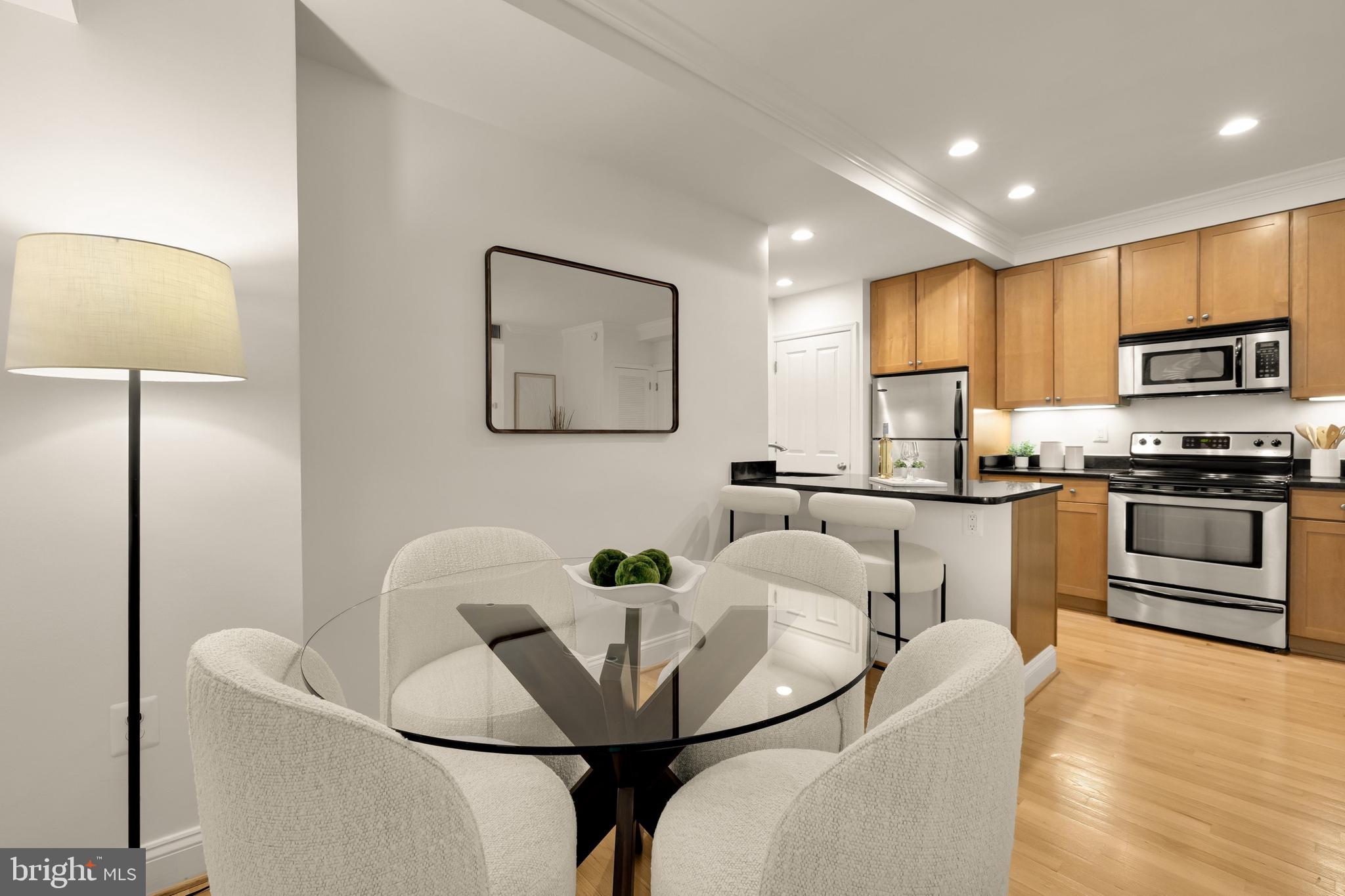 1701 16th Street Northwest, Unit 822 Washington, DC 20009 - Photo 6 of 19 a kitchen with stainless steel appliances granite countertop a microwave a stove a sink a microwave a dining table and chairs