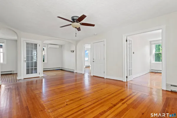 a view of a livingroom with wooden floor and a ceiling fan