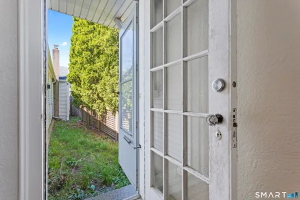 a view of a porch with a floor to ceiling window and garden