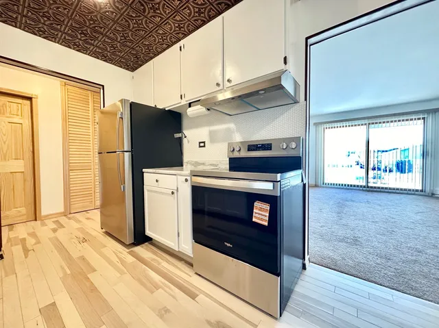 a kitchen with stainless steel appliances a stove a refrigerator and cabinets