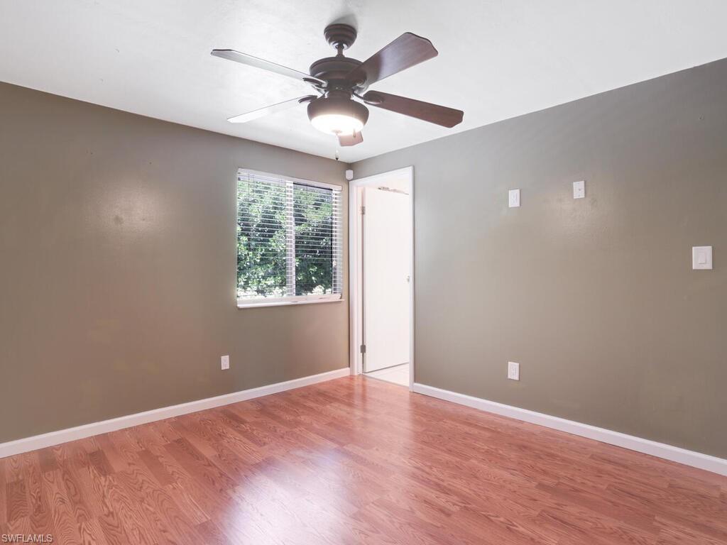 9101 Hamlin Road West Fort Myers, FL 33967 - Photo 17 of 24 an empty room with wooden floor ceiling fan and windows
