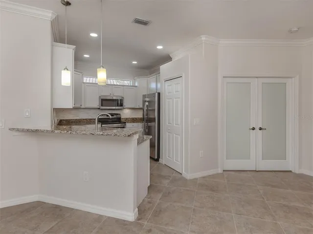an empty room with wooden floor closet and windows