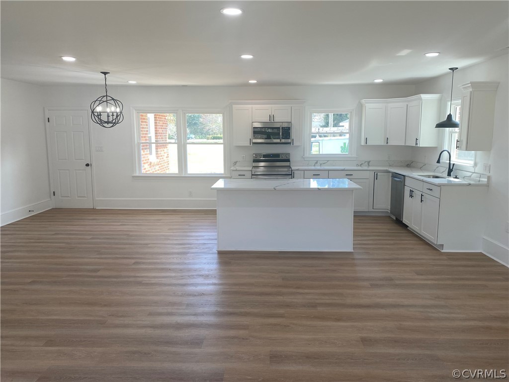 13462 Cabin Point Road Stony Creek, VA 23882 - Photo 5 of 30 a large white kitchen with kitchen island a sink wooden floor and a large window