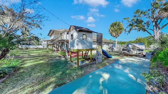 a aerial view of a house next to a big yard and large trees