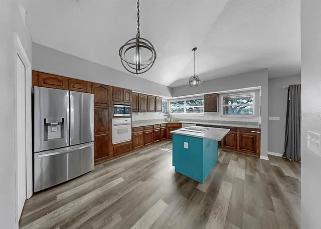 a kitchen with cabinets stainless steel appliances and a counter space
