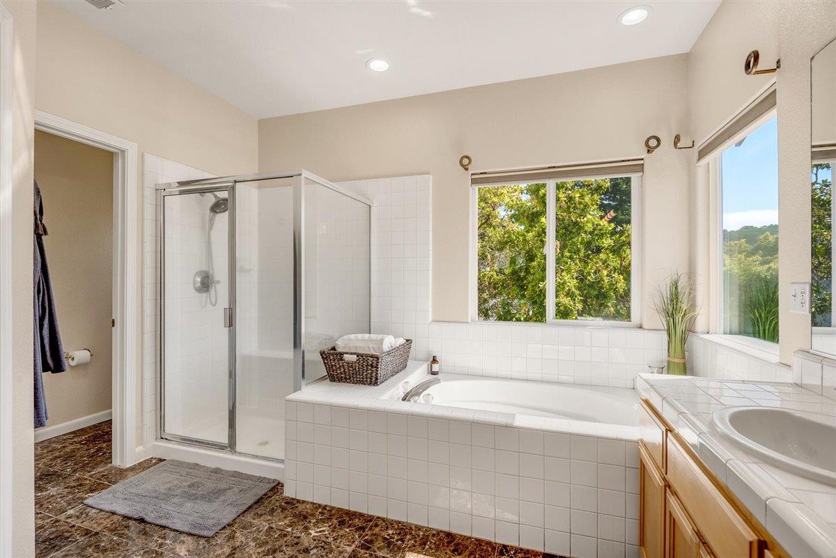 1416 Casablanca Circle Gilroy, CA 95020 - Photo 19 of 32 a bathroom with a tub a sink a mirror and a shower