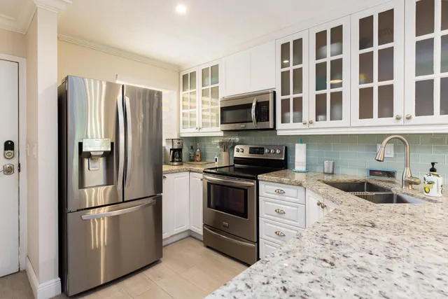 a kitchen with stainless steel appliances granite countertop a sink and a refrigerator