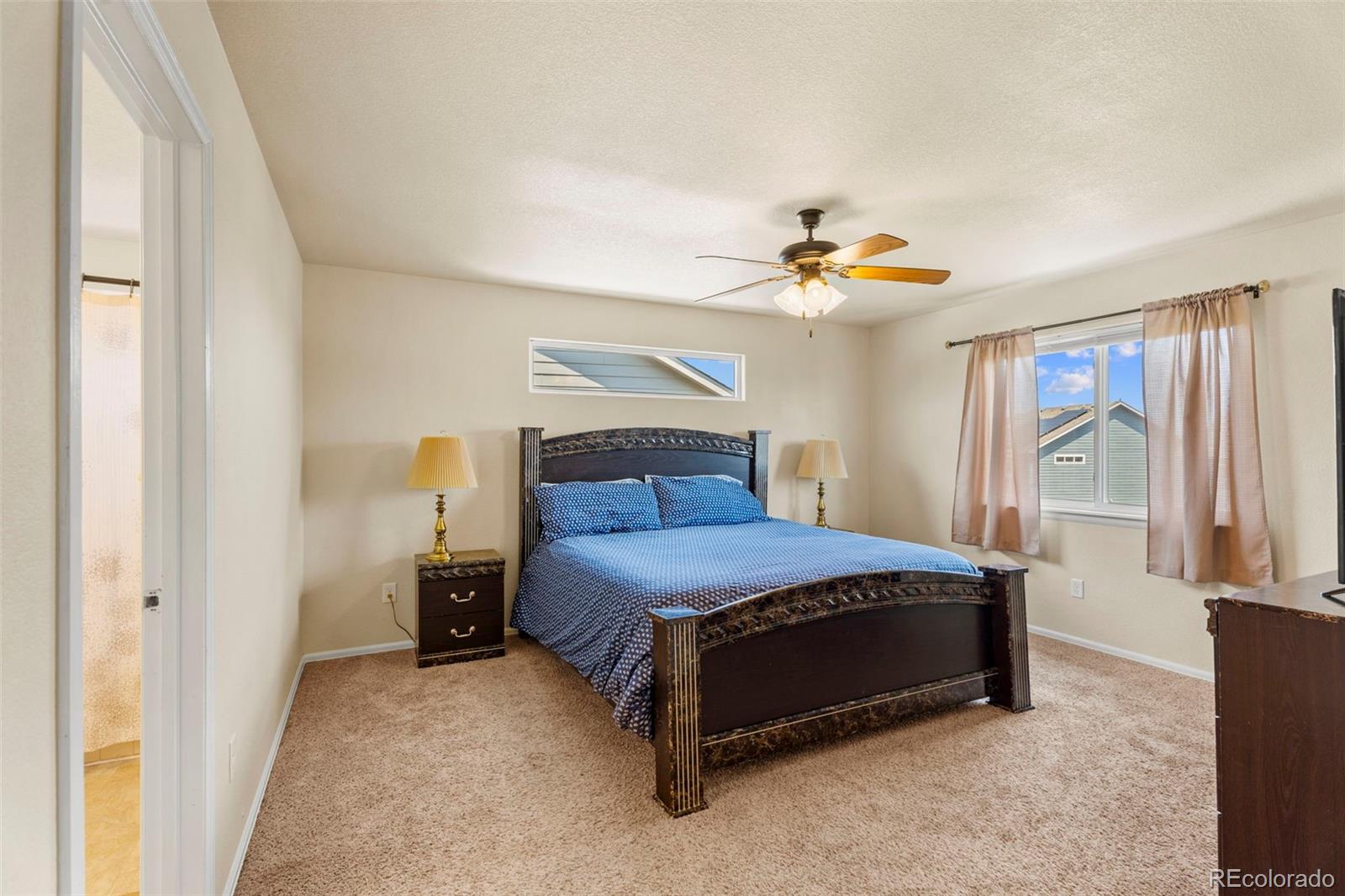 4651 Dancing Rain Way Colorado Springs, CO 80911 - Photo 17 of 32 a bedroom with a bed and a chandelier