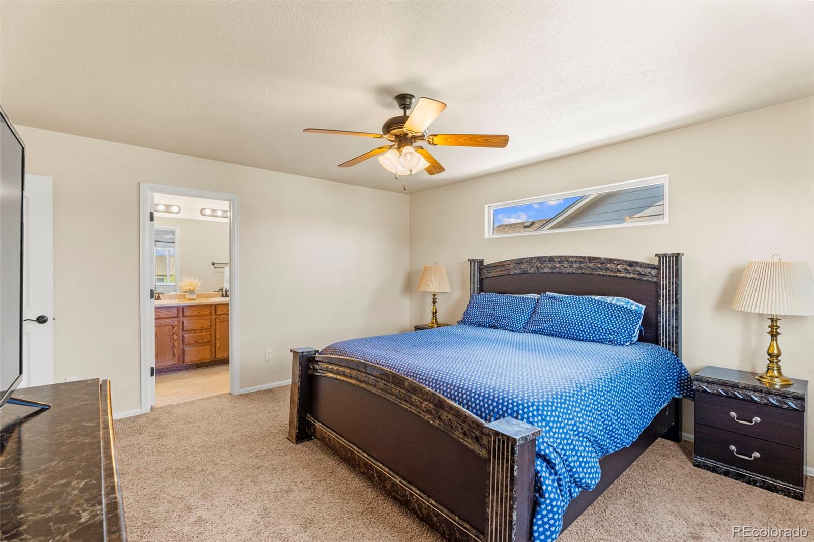 4651 Dancing Rain Way Colorado Springs, CO 80911 - Photo 18 of 32 a bedroom with a bed and a chandelier