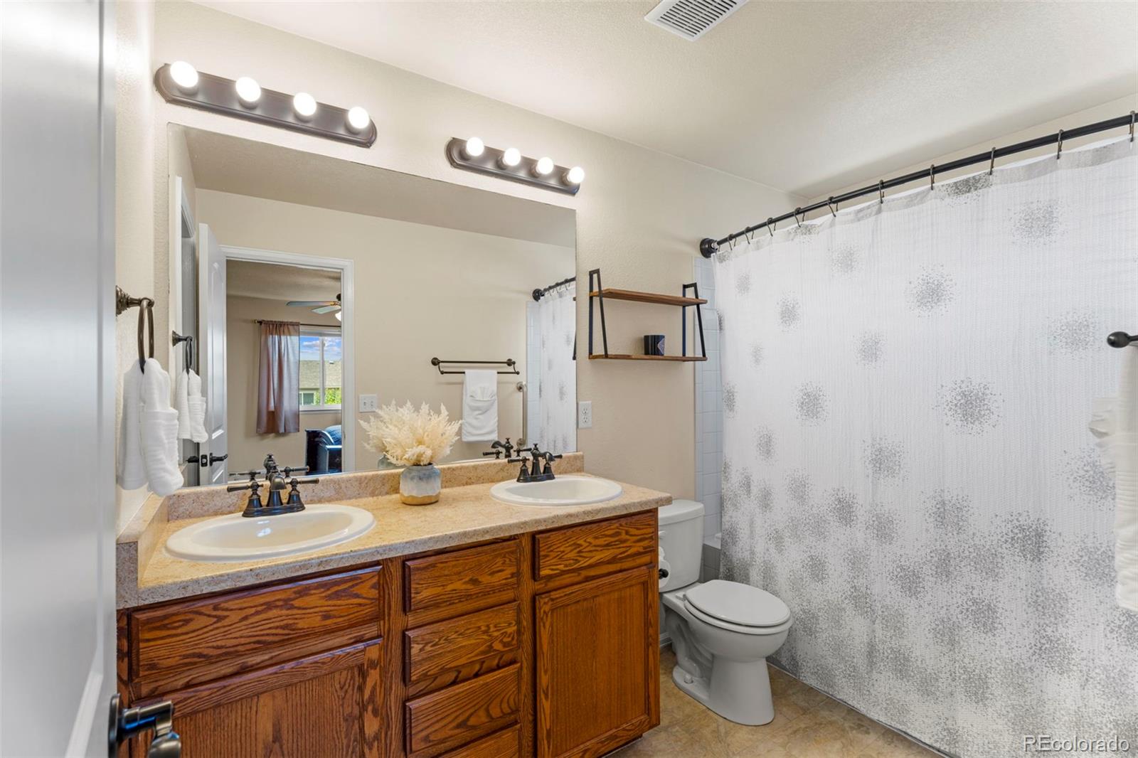 4651 Dancing Rain Way Colorado Springs, CO 80911 - Photo 19 of 32 a bathroom with a double vanity sink mirror and toilet