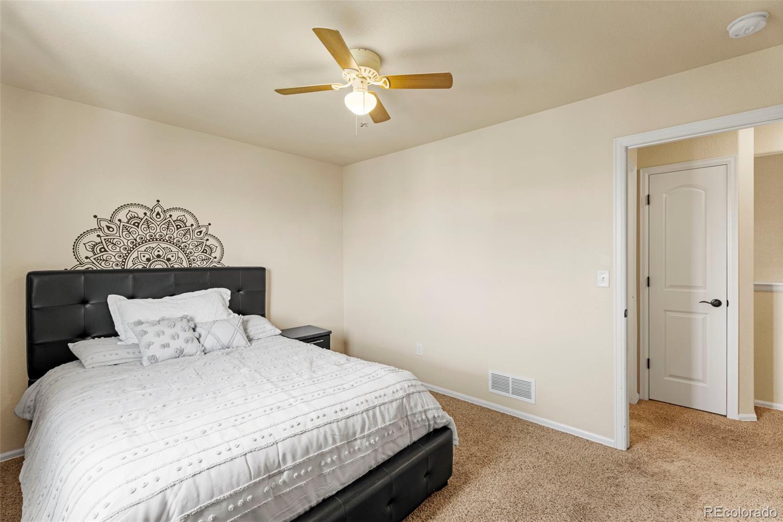 4651 Dancing Rain Way Colorado Springs, CO 80911 - Photo 22 of 32 a bedroom with a bed and a ceiling fan