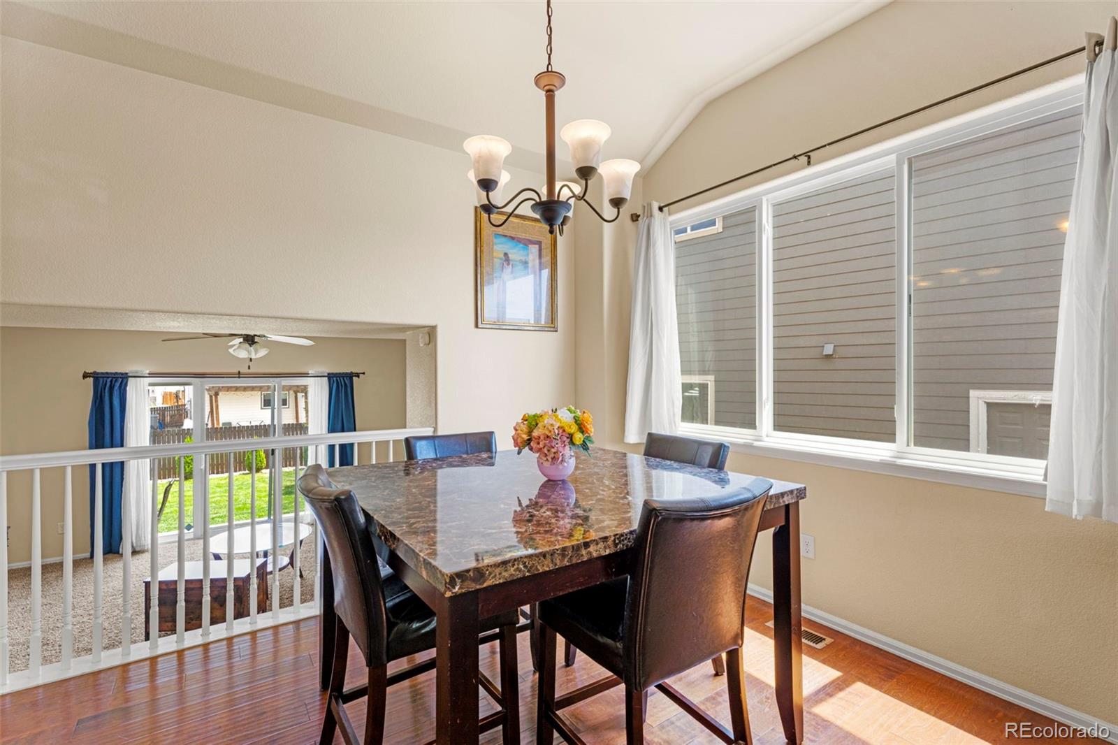 4651 Dancing Rain Way Colorado Springs, CO 80911 - Photo 23 of 32 a dining room with furniture a chandelier and wooden floor