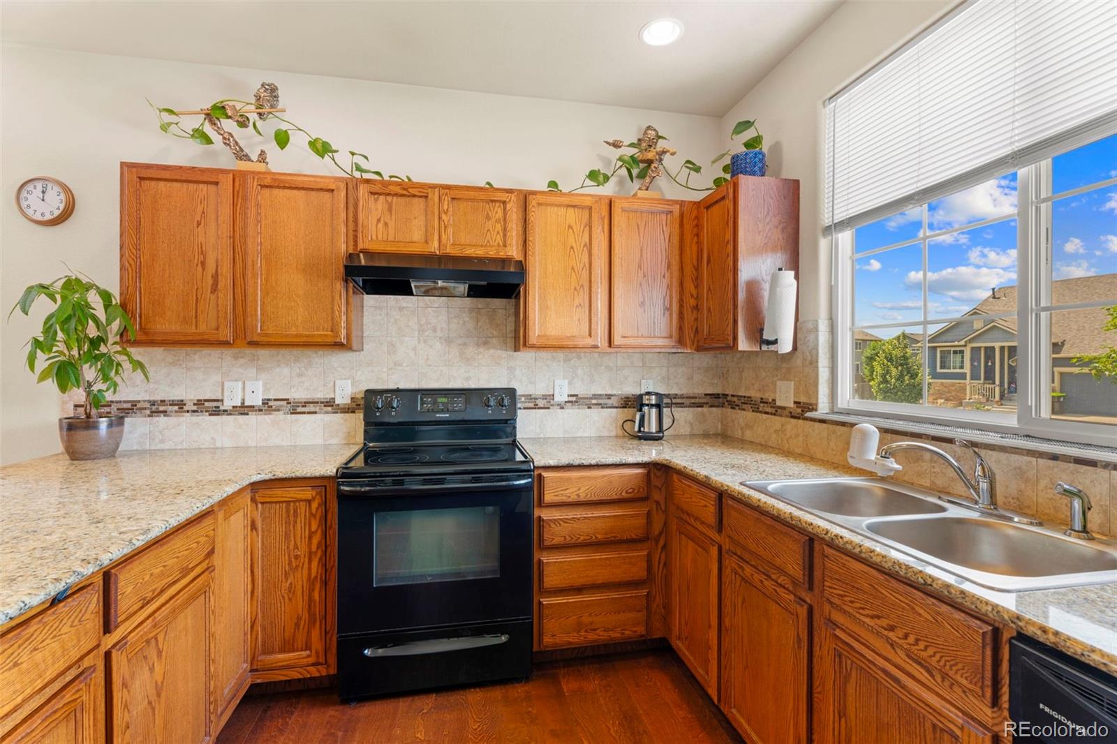 4651 Dancing Rain Way Colorado Springs, CO 80911 - Photo 8 of 32 a kitchen with granite countertop stainless steel appliances a sink window and cabinets