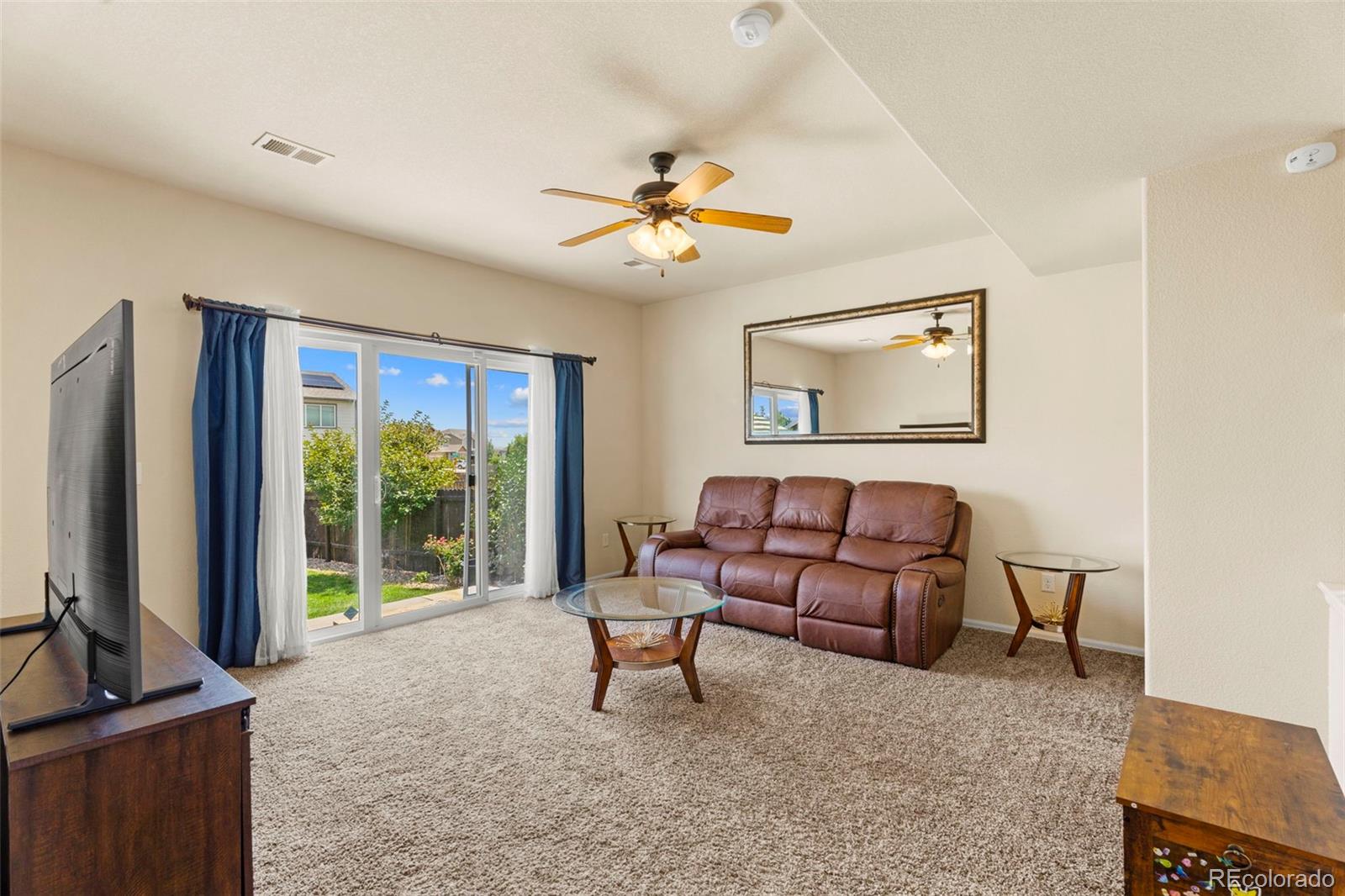 4651 Dancing Rain Way Colorado Springs, CO 80911 - Photo 9 of 32 a living room with furniture and a flat screen tv