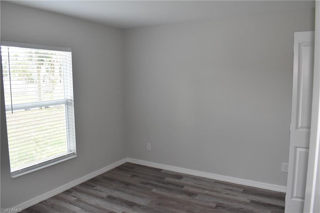 2295 Saturday Street North Port, FL 34288 - Photo 18 of 20 Empty room with dark wood finished floors and baseboards