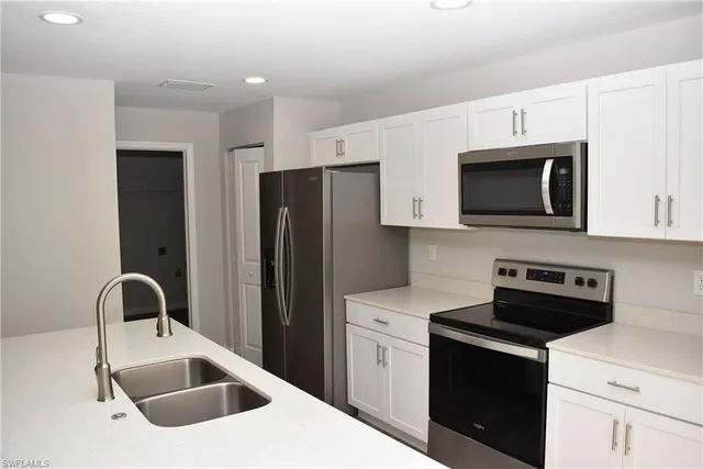 a kitchen with stainless steel appliances a stove microwave sink and refrigerator