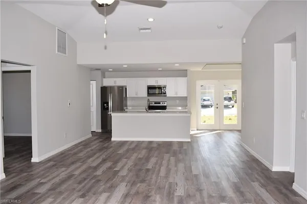 a view of kitchen with kitchen island wooden floor center island and stainless steel appliances