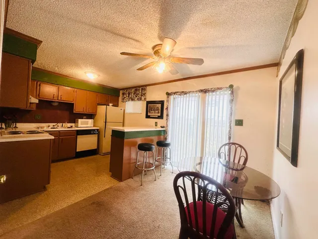 a kitchen with granite countertop a stove a sink and a refrigerator with wooden floor
