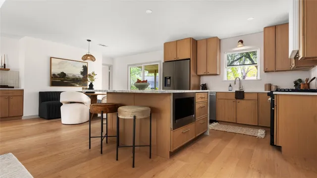 a kitchen with table chairs cabinets and stainless steel appliances